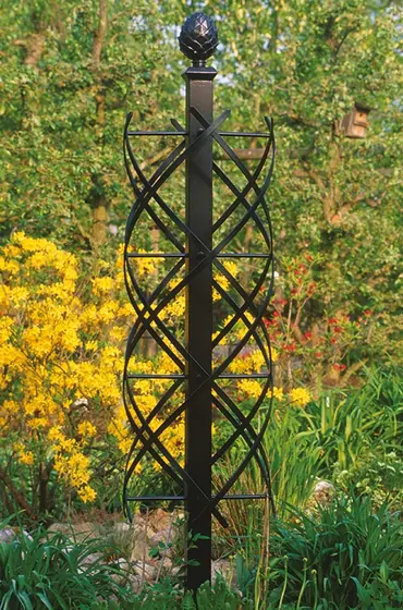 Iron garden obelisk among yellow and pink blooms