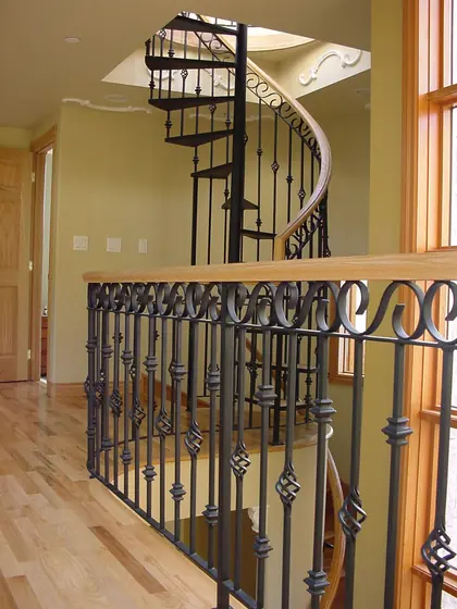 Scrolled iron balusters beneath a spiral staircase