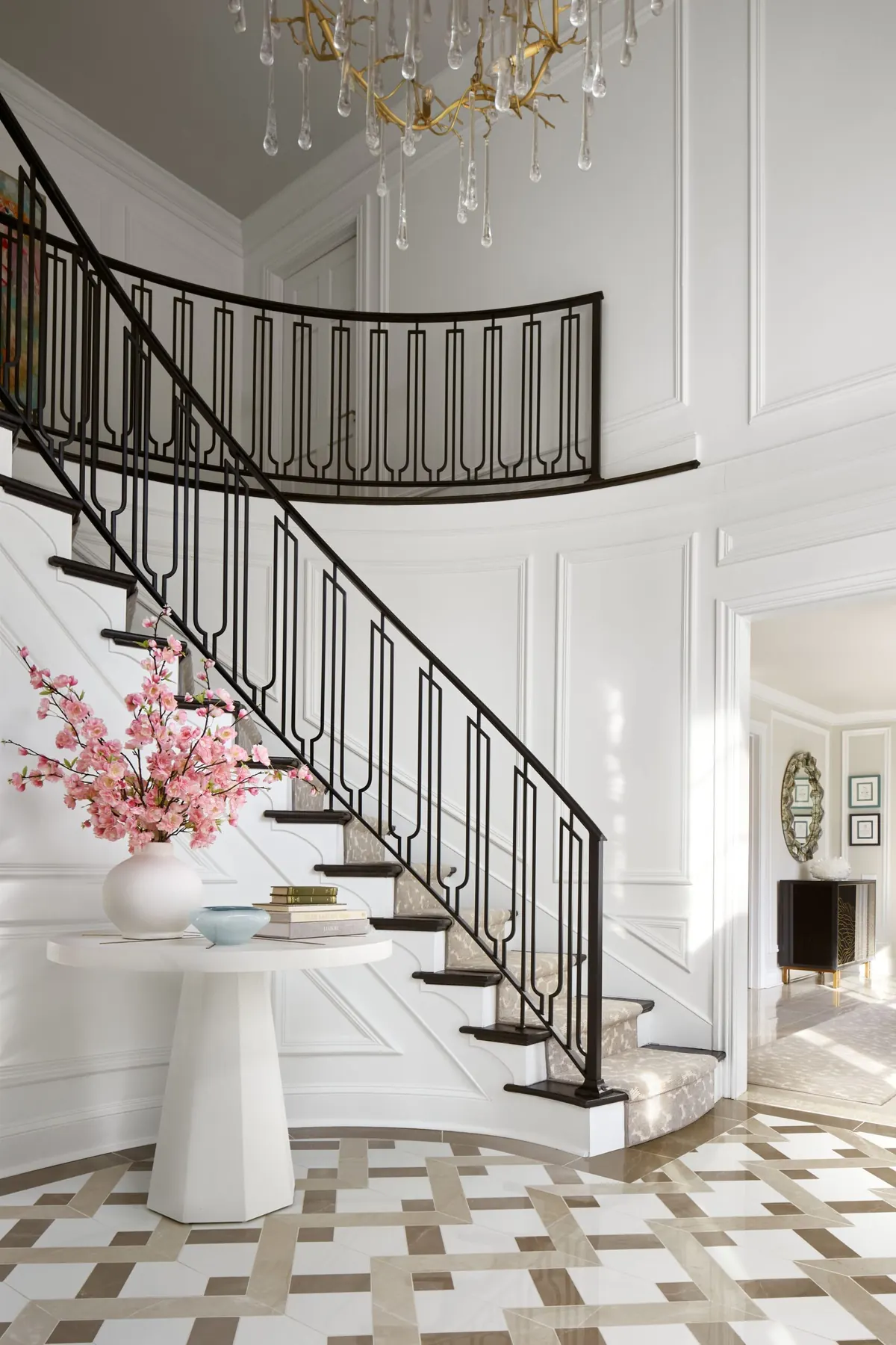 Curved foyer staircase with a custom black iron railing